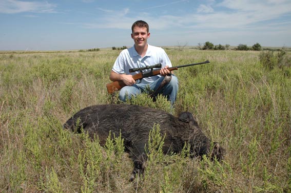 Hunter posing with wild boar kill.